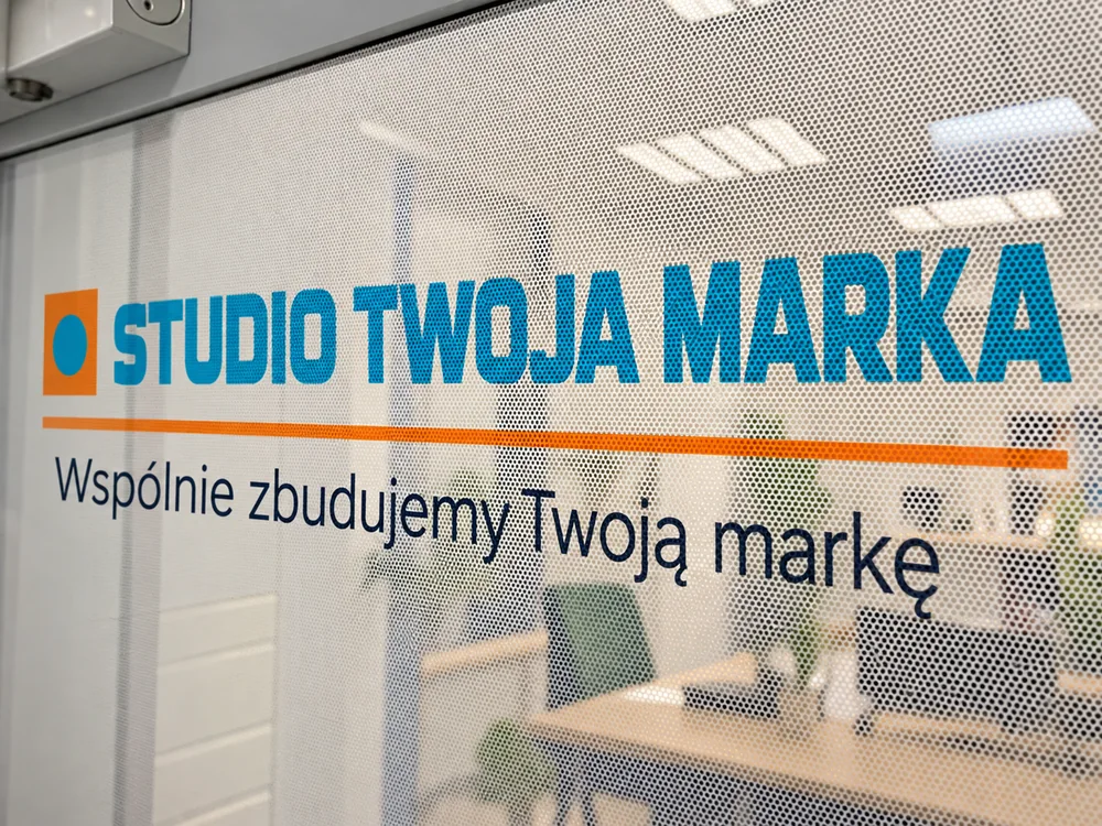 Folia OWV One Way Vision z własnym nadrukiem Folia OWV na szybie biura – grafika widoczna z zewnątrz, perforacja przepuszcza widok z wnętrza (wizualizacja)